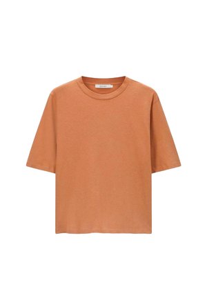 Short-sleeved t-shirt in rust orange, made of soft cotton material, featuring a round neckline and a relaxed fit, with no visible logos.