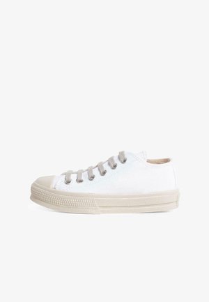 Baskets en toile blanches avec des accents beiges, à bout rond et six œillets. Présentent une semelle en caoutchouc texturé et un design à coupe basse.
