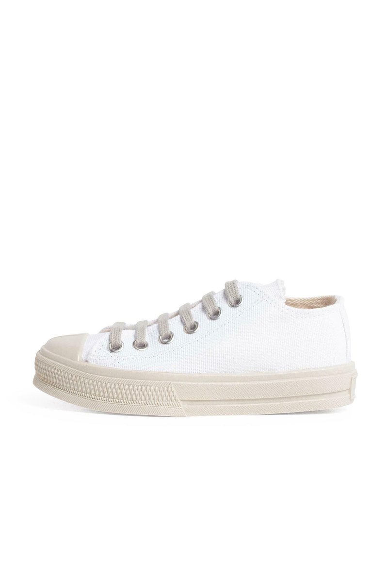 White canvas sneaker with beige accents, round toe, and six eyelets. Features a textured rubber sole and a low-cut design.