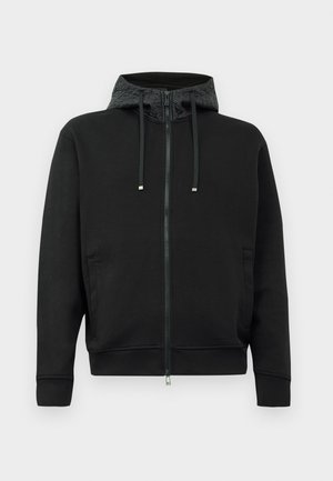 Sort zip-up hoodie lavet af blødt stof. Har mønstret foret i hætten, snoretræk og sidelommer. Glat tekstur, afslappet pasform.