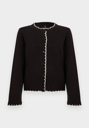 Svart cardigan med bølget hvit kant langs halsen, knappelukking og mansjetter. Laget av et mykt, teksturert materiale.