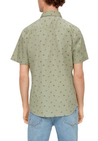 Grün kurzärmliges Hemd mit dezentem floralem Muster, glatter Textur, klassischem Kragen und abgerundetem Saum, getragen mit hellblauen Jeans.