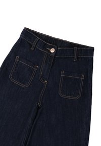 Jeans de mezclilla oscura con corte recto, presentan herrajes de botón de cobre y costuras en contraste. Dos bolsillos traseros con un diseño clásico.