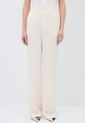 Pantalon large beige avec des rayures verticales, fabriqué en tissu léger. Il présente une taille haute et un devant plat avec des poches latérales.