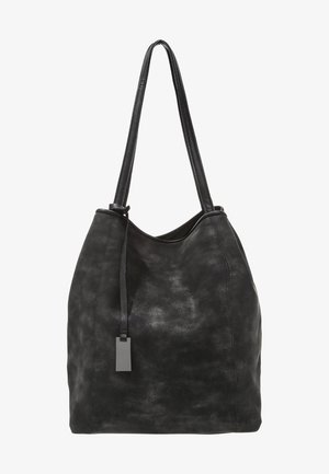 Czarna torebka na ramię z miękkiej skóry z długimi uchwytami i małą, prostokątną metką zawieszoną na pasku.