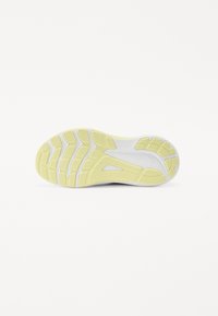 Semelle de chaussure avec une semelle extérieure en caoutchouc jaune texturé et une semelle intermédiaire blanche. Présente de profondes rainures pour une adhérence et un design épuré.