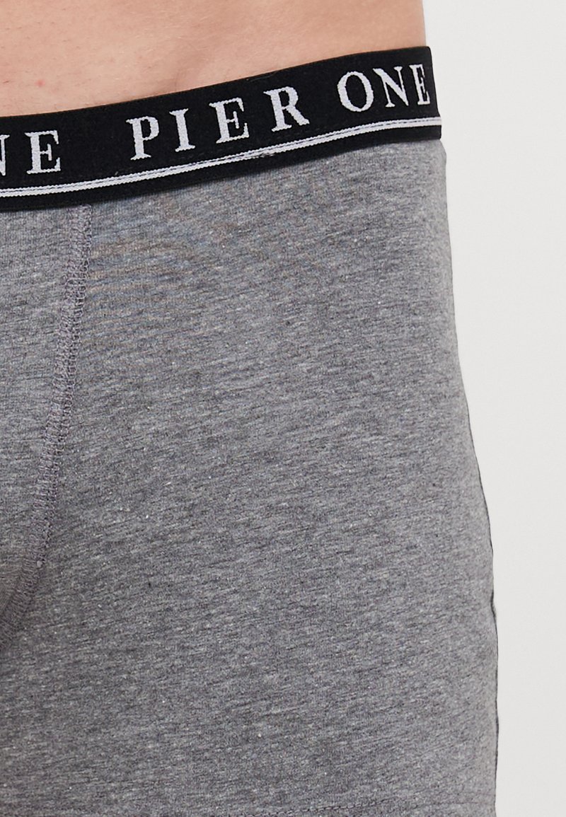 Boxer ajustados de algodón gris con una cinturilla negra que presenta "PIER ONE" en letras blancas y una tira de acento gris en contraste.