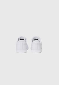 Witte sneakers van glad leer, lage schoenontwerp, ronde neus en platte rubberen zolen; minimale stiksels en geen opvallende accenten.
