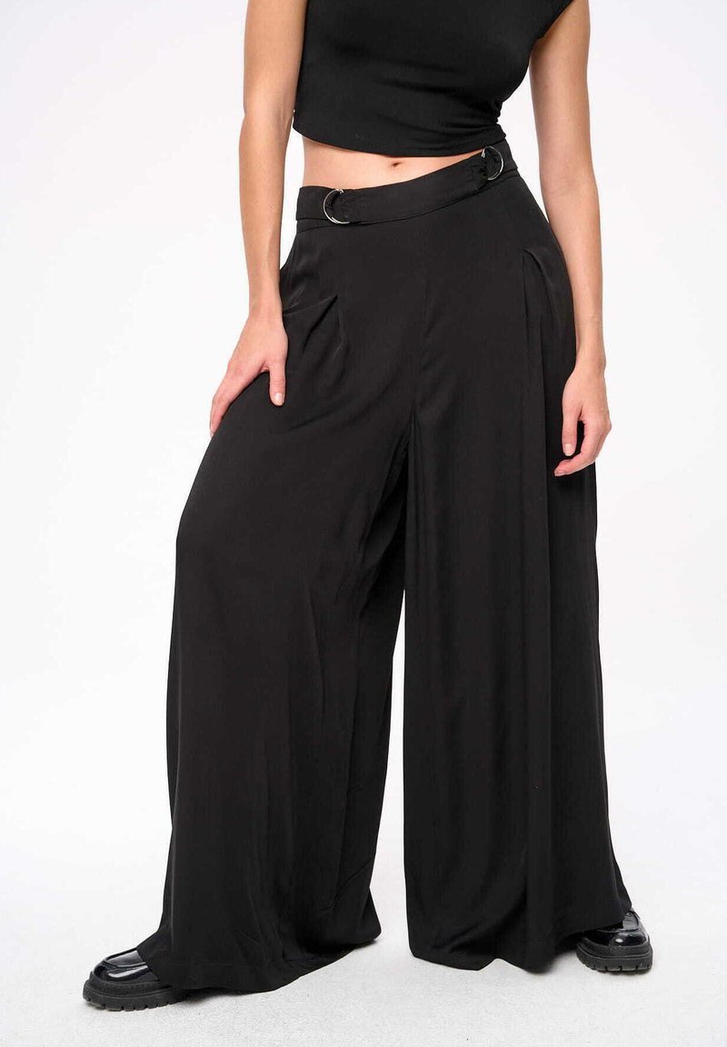 Zwarte wijde broek met een losse pasvorm, voorzien van een hoge taille, een riem met cirkelvormige hardware en zijzakken. Glad, lichtgewicht stof.