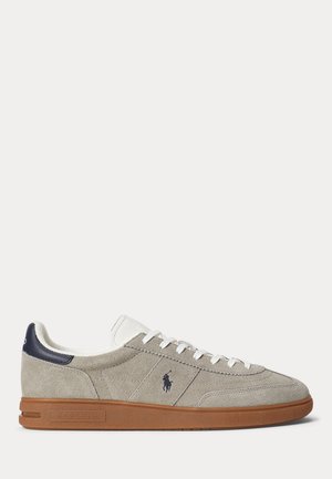 Low-top grey suede sneaker with white laces, navy heel tab, brown rubber sole, and Polo Ralph Lauren logo on the side.