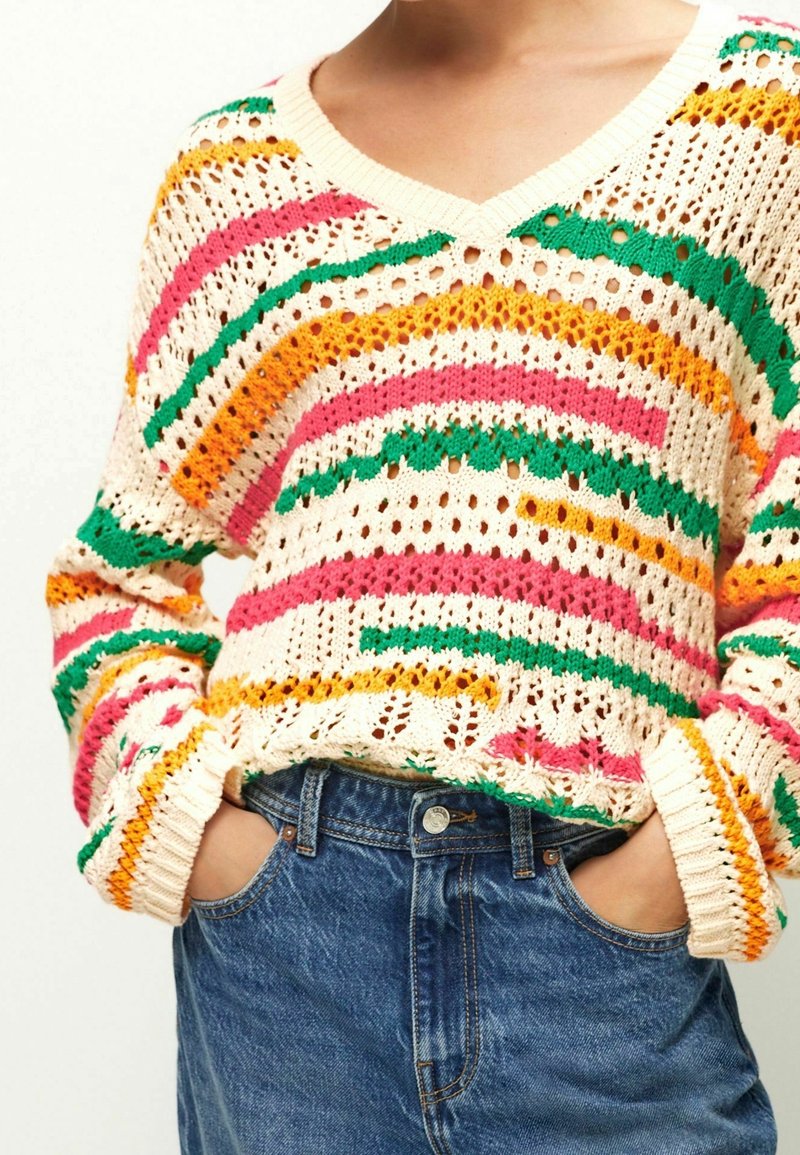 Strickpullover mit V-Ausschnitt in Creme, versehen mit bunten Streifen in Pink, Orange und Grün, offen gearbeiteten Textur und gerippten Bündchen.
