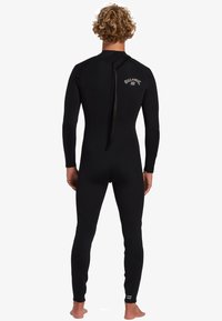 Traje de neopreno negro, confeccionado en material elástico, con cremallera en la espalda, mangas largas y costuras reforzadas para mayor durabilidad.