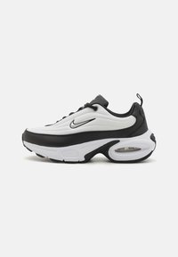 Nike sneaker met een witte bovenkant van textured stof, zwarte accenten, een opvallende tussenzool en een zichtbare luchtkusseneenheid.