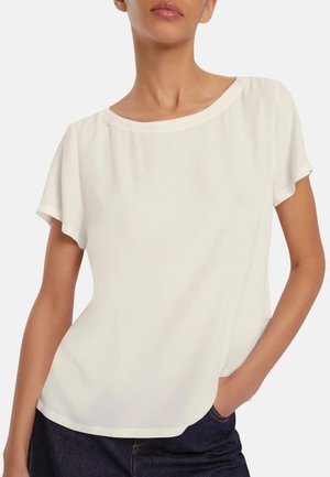 Blusa bianca a maniche corte con scollo rotondo, realizzata in tessuto morbido. Presenta una vestibilità rilassata e una leggera caduta ai lati.
