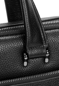 Zwarte leren handtas met een gestructureerd oppervlak, dubbele handvatten en zilverkleurige ritssluiting.