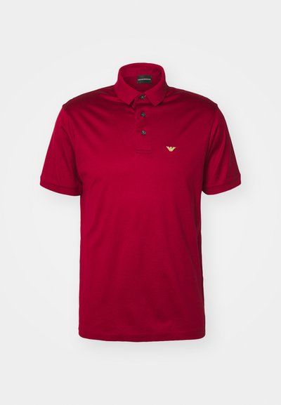 Röd polo skjorta i bomull med klassisk krage, platta med tre knappar, korta ärmar och en liten gyllen logotyp på vänster bröst.