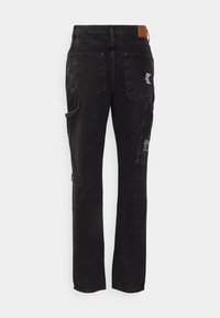 Czarne dżinsowe spodnie cargo o prostym kroju, z tylkimi kieszeniami, boczną kieszenią oraz subtelnymi przetarciami. Skórzana naszywka w pasie.