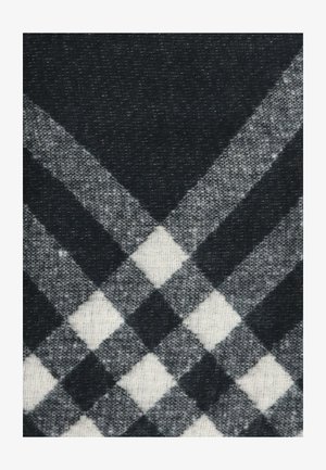 Tessuto a scacchi in bianco e nero con una trama testurizzata, caratterizzato da motivi a diamante e quadrati alternati. I bordi sono puliti e ben definiti.