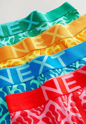 Colorful men's underwear bands in green, blue, orange, yellow, and red with contrasting patterns and the brand "NEXT" in bold lettering.