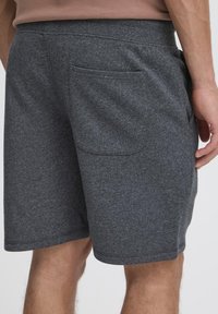 Grå bomuldsblandingsshorts med elastik i taljen, sidelommer og en enkelt baglomme. Blød tekstur og afslappet design.