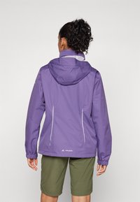 Purple waterproof jacket with a hood, featuring white trim, a zippered front, and elastic cuffs. Worn over green shorts.