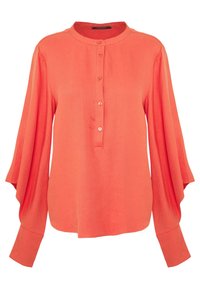 Blouse corail boutonnée avec un col rond, des manches longues et une coupe fluide. Dotée de larges manches et de cinq boutons à l'avant.