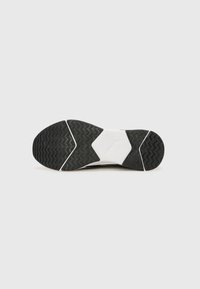 Black and white athletic shoe sole with textured grip pattern, featuring a prominent logo and geometric shapes on the outsole.