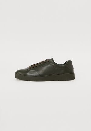Dark green low-top leather sneaker with matching laces and rubber sole, shown in profile on a plain light background.