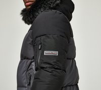 Black puffer jacket with a detachable faux fur hood, featuring zippered pockets and “KINGS WILL DREAM” logo on the sleeve.