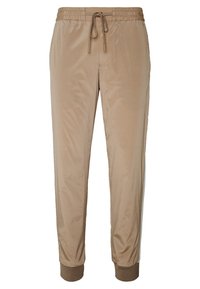 Pantalones jogger beige de tela suave, con cintura elástica y cordón ajustable, y puños ceñidos en los tobillos.