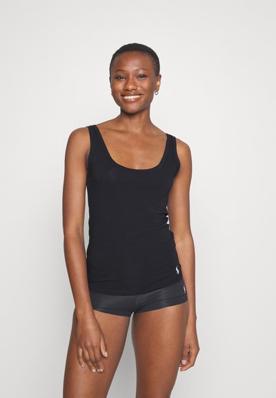Black fitted tank top made of cotton, featuring a wide neckline and narrow straps. Paired with black shorts, minimal branding visible.