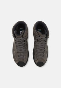 Graue Wildleder High-Top-Schuhe mit dunklen Gummisohlen, ausgestattet mit einer Schnürdesign und verstärkter Zehenpartie für Langlebigkeit. Das Innere hat eine gepolsterte Fütterung.
