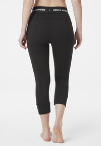 Černé zkrácené legíny z elastického materiálu, s širokým páskem a logem "HELLY HANSEN". Elegantní design s hladkým povrchem.