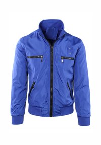 Giacca leggera blu con colletto rialzato, apertura con zip e tasche con zip multiple con accenti neri. Texture liscia e lucente.