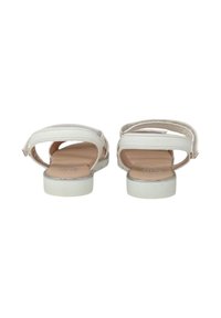 Sandali bianchi con cinturini regolabili, suola piatta e texture liscia. Presentano un leggero tacco e un design minimalista.