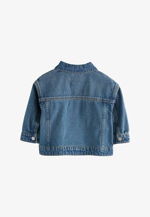 Keskmise sinise värvi teksajakk, klassikalise kraega, pikad varrukad ning nupud mansettidel ja ees. Omab sirget lõiget ja taga paneeli.