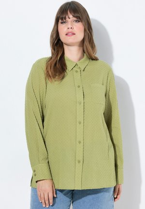 Olijfgroene langemouwen shirt van een gestructureerde stof, met een kraag, knoopsluiting voor en een enkele borstzak. Casual pasvorm met knoopmanchetten.