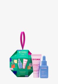 Die Verpackung des BYOMA Star Power Duo zeichnet sich durch ein farbenfrohes geometrisches Design mit pinken Akzenten aus und enthält eine Tube mit pinkem Gel-Creme und eine Flasche mit blauem Serum.