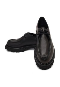 Zapatos de cuero negro con acabado suave, puntera redondeada, diseño de cordones y suela de goma texturada para mayor tracción.