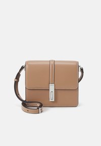 Hnědá kožená kabelka přes rameno s obdélníkovým tvarem, přední klopou, stříbrným kováním a kontrastním prošíváním. Součástí je nastavitelný popruh.