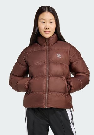 Het bruine pufferjack met een hoge kraag, ritssluiting, elastische manchetten en zijzakken. Voorzien van het witte Adidas-logo op de borst.
