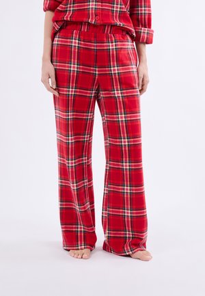 Ensemble de pyjama à carreaux rouges en tissu doux. Le pantalon présente une coupe décontractée, une taille élastique et un motif tartan classique avec des accents noirs et blancs.