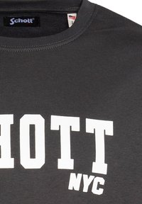 T-shirt grigio a maniche corte con finitura testurizzata, caratterizzato da un'accattivante scritta bianca "SCHOTT NYC" in carattere in grassetto attraversando il petto.