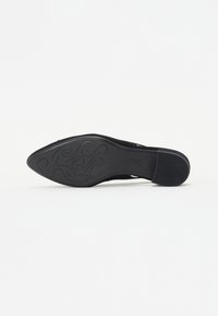 Chaussure à talon haut noire avec un bout pointu, un matériau supérieur texturé et une semelle lisse ornée d'un motif décoratif.