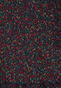 Tela azul oscuro con pliegues que presenta un denso patrón de pequeñas flores rojas, amarillas y azules con hojas verdes.