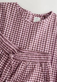 Rochie cu model gingham în nuanțe de maro și roz, cu decolteu rotund, talie elastică și detalii adunate. Material ușor, cu finisaj texturat.