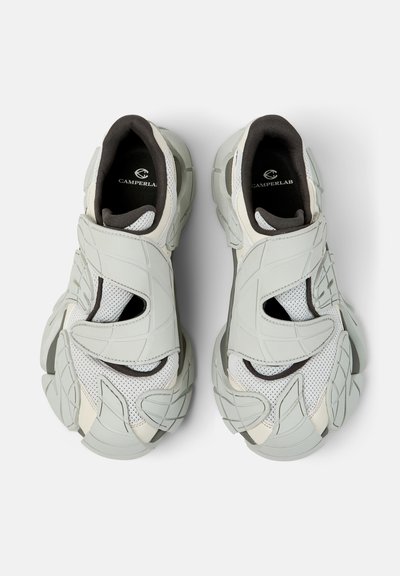 Baskets épaisses blanches et grises avec tissu en mesh, semelles épaisses texturées, et larges brides auto-agrippantes de Camperlab, vues de dessus.