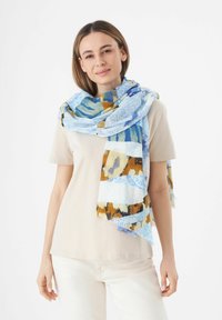 Écharpe multicolore avec des motifs abstraits en bleu, cyan, marron et blanc, fabriquée dans un tissu léger au toucher doux.