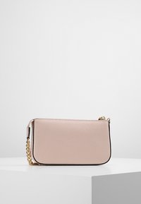 Borsa a tracolla in pelle rosa con superficie testurizzata, tracolla in catena dorata e design minimalista. Chiusura con zip lungo il bordo superiore.