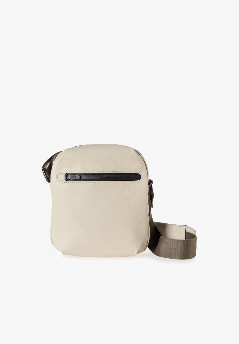 Beige Umhängetasche mit glatter Textur, einem oberen Reißverschluss und einem verstellbaren braunen Tragegurt. Eine vordere Reißverschlusstasche bietet zusätzlichen Stauraum.